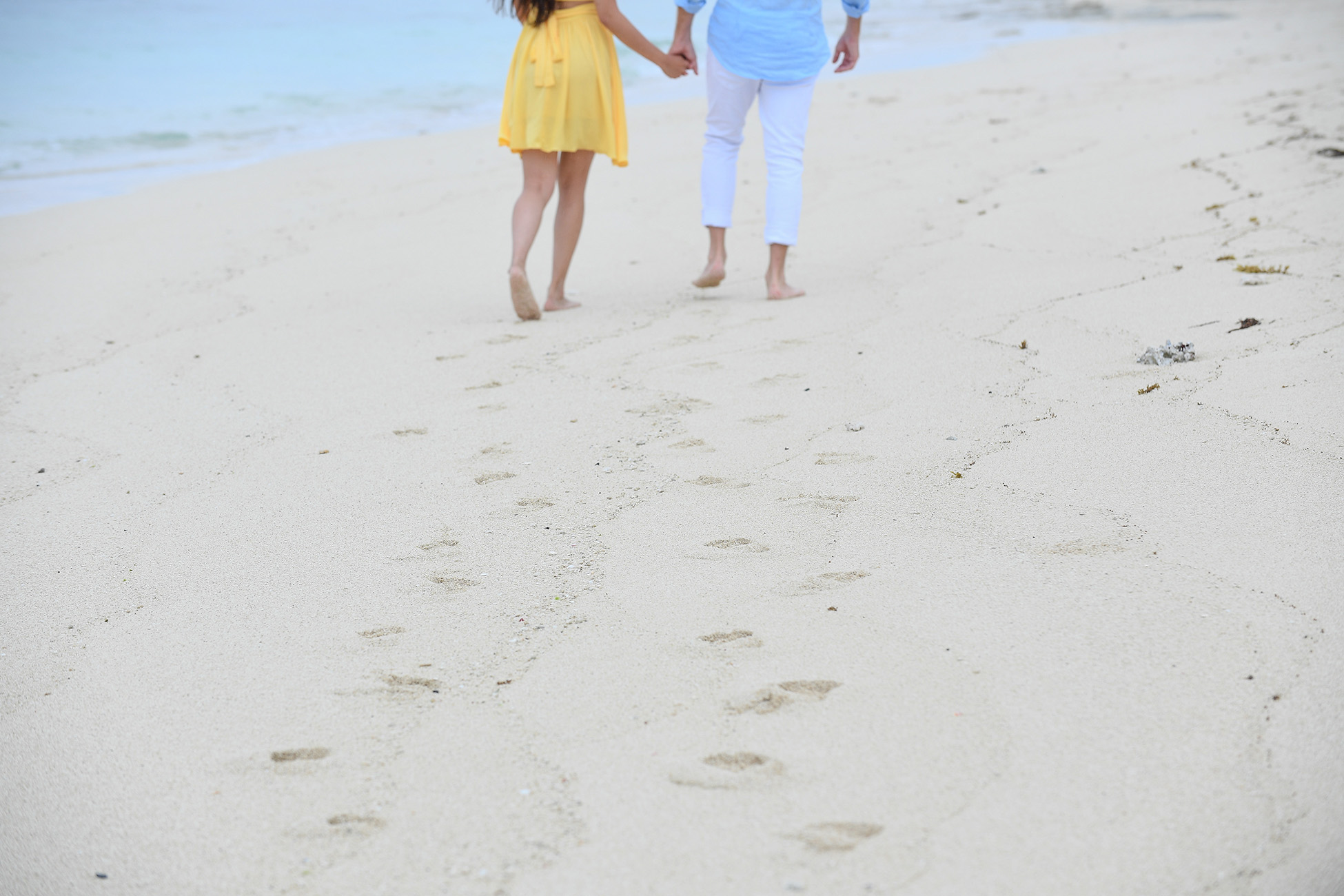 The newly engaged couple leave footprints on the beige Mamanunca beach of Fiji