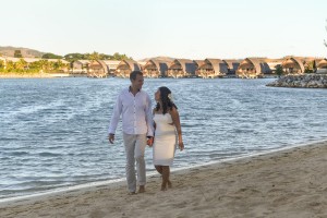 The couple strolls hand in hand along the Fiji beach at sunset