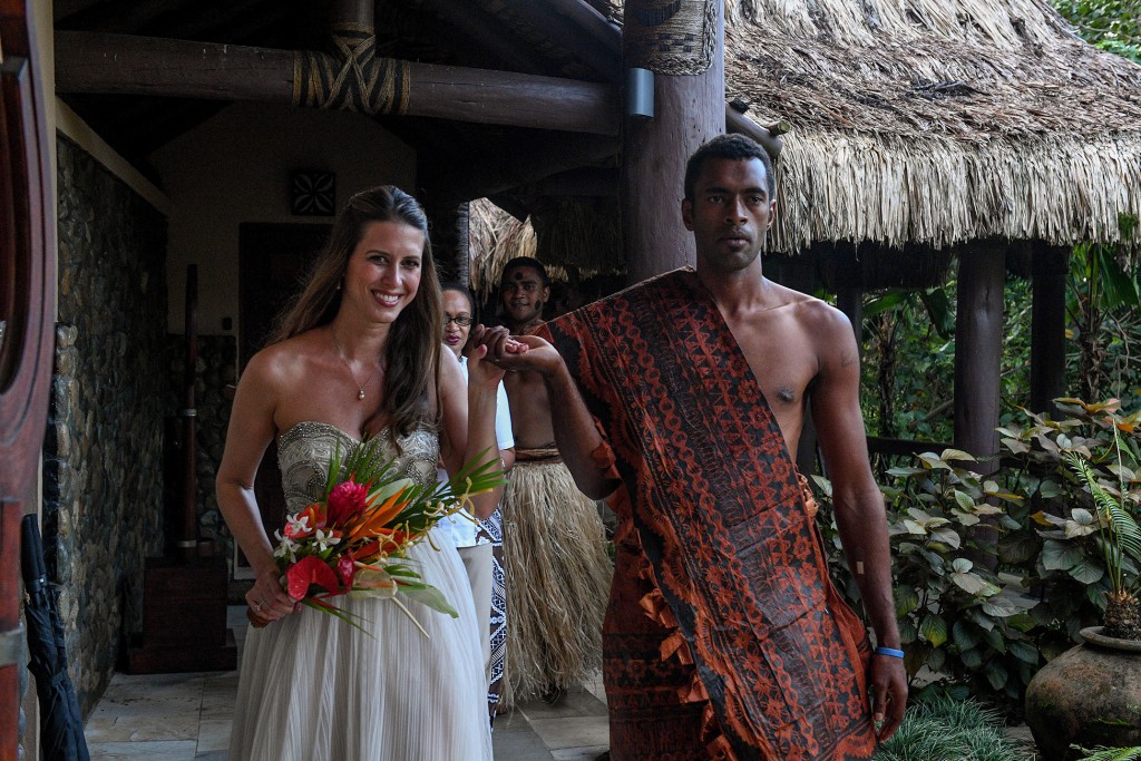 The stunning bride is escorted by a traditional Fiji warrior