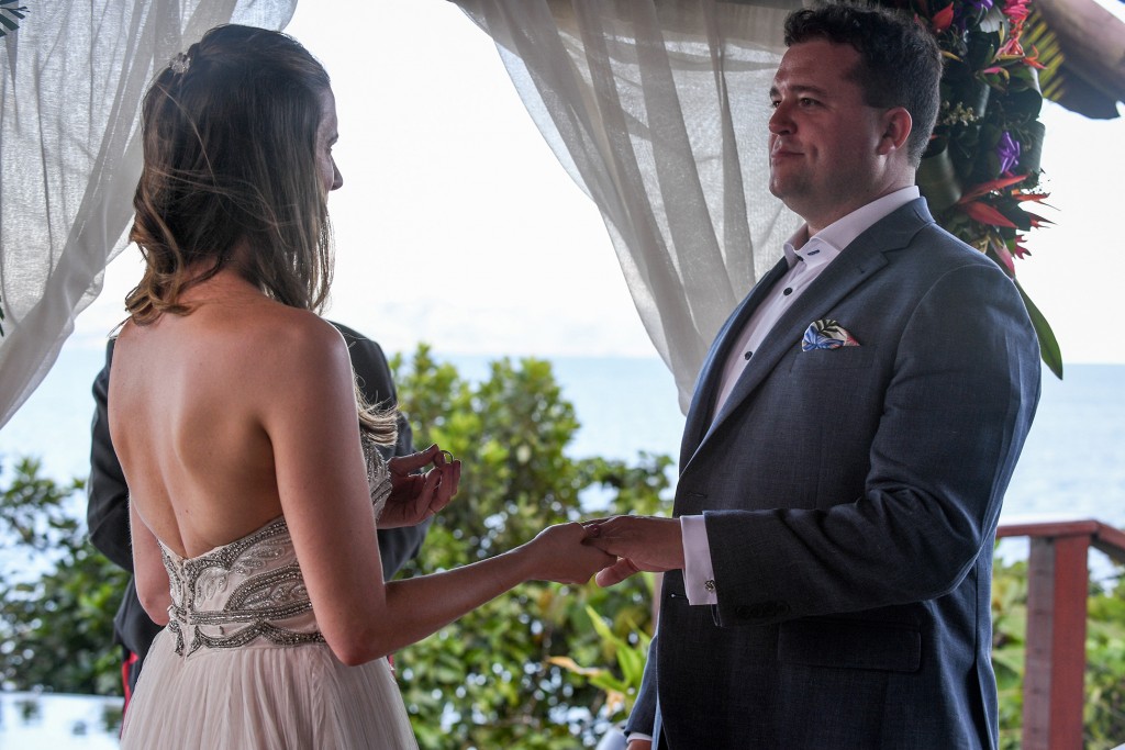 The bride says her vows before she slips the groom's ring on his finger