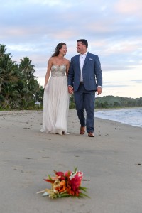 The newly weds share laughter while strolling on the beach