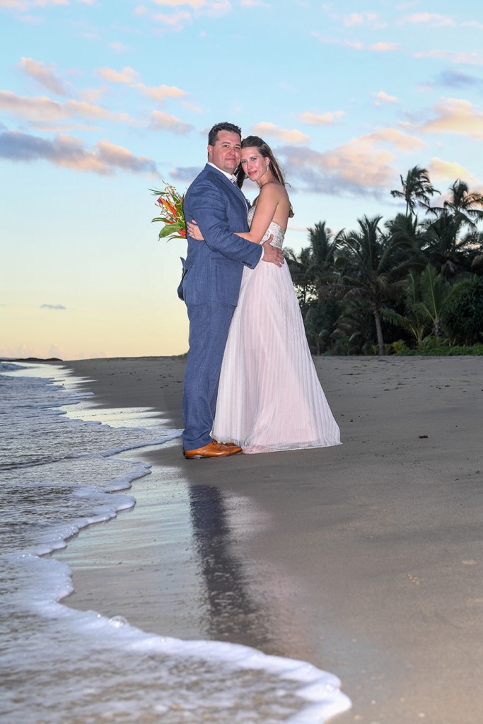 The couple embrace on the black sand beach of the Nanuku coral coast