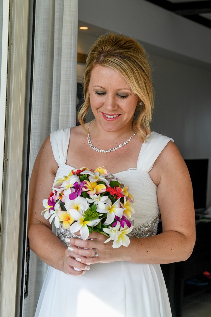 The bride poses with her colourful tropical flower bouquet