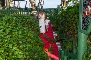 The bride walks down a red carpet aisle with the her son