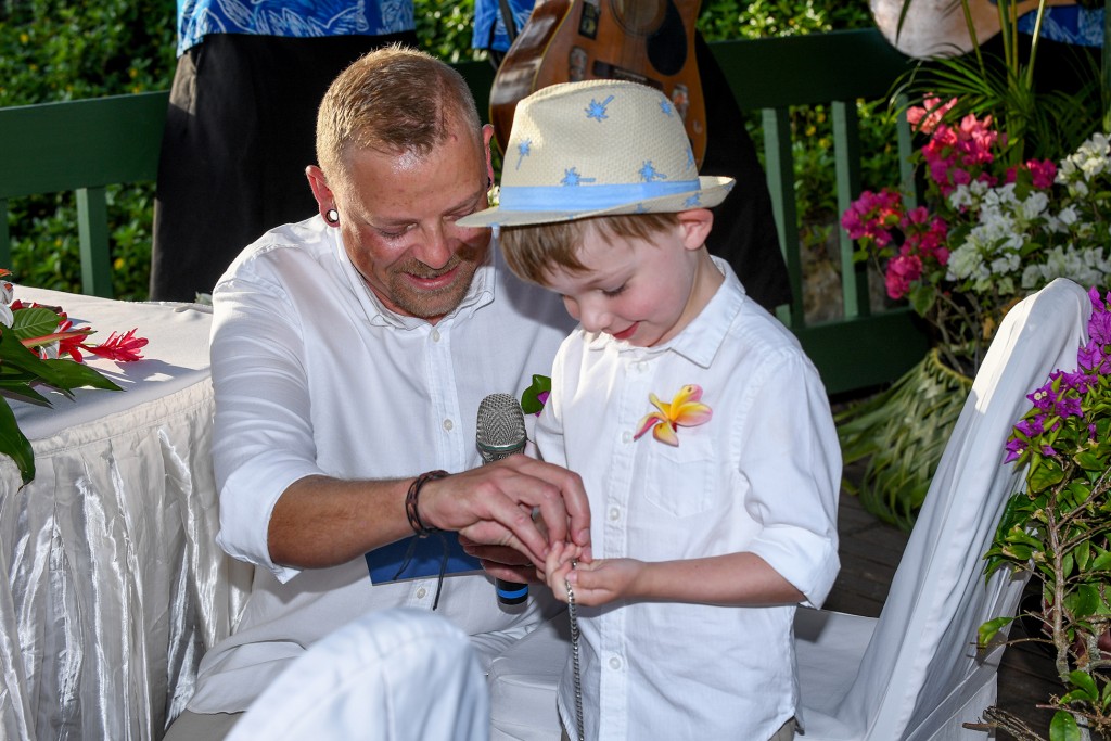 The groom helps his son unstring the rings