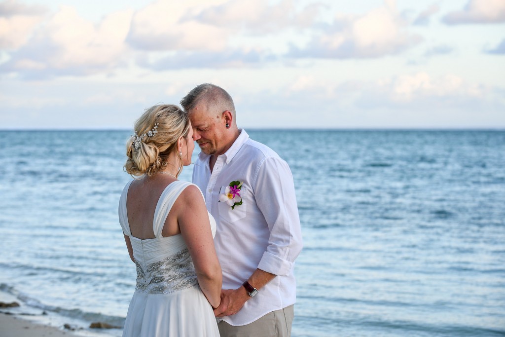 The newly weds share an intimate moment beside the ocean