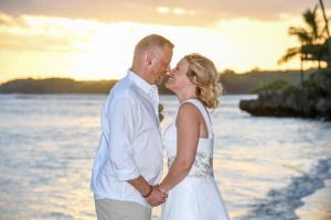 The newly weds share an intimate moment against a fiery Fiji sunset