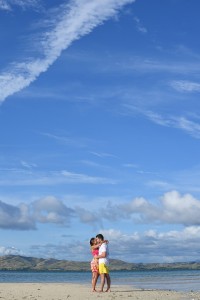 The couple passionately kiss against the deep blue skies of Nadi Fiji