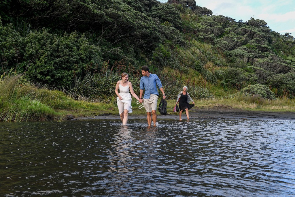 The couple walk to the marriage spot through shallow waters of Karekare beach