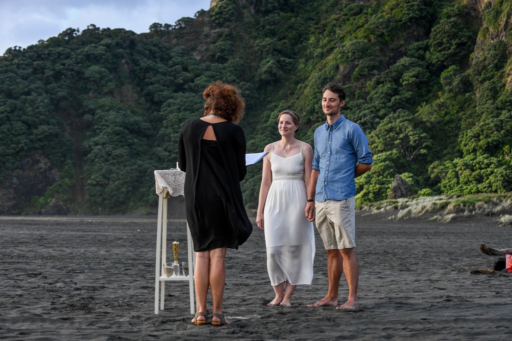 The celebrant leads the marriage ceremony on the black sand beach