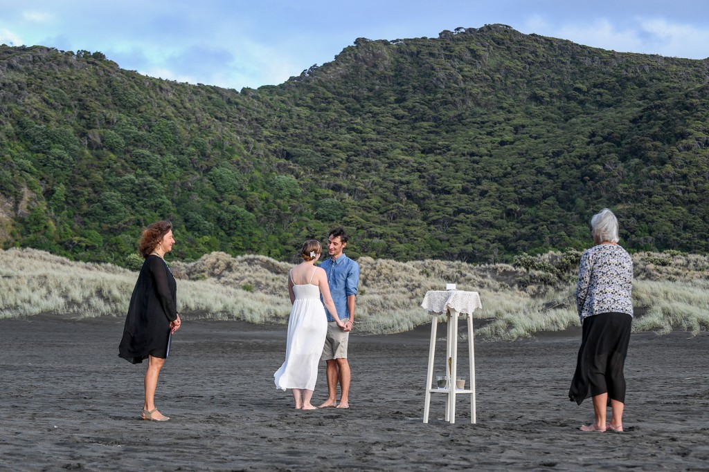 The couple exchanges vows on black sand Karekare beach