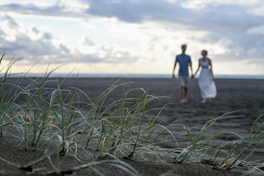 An out of focus image of the newly weds on the black sand beach