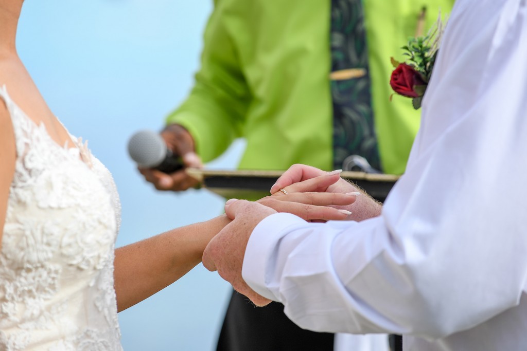 The groom slips the ring on the bride's finger