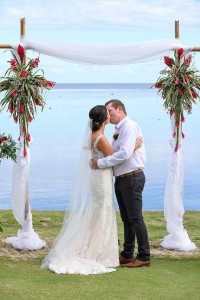 The newly weds kiss at the altar overlooking the Pacific ocean