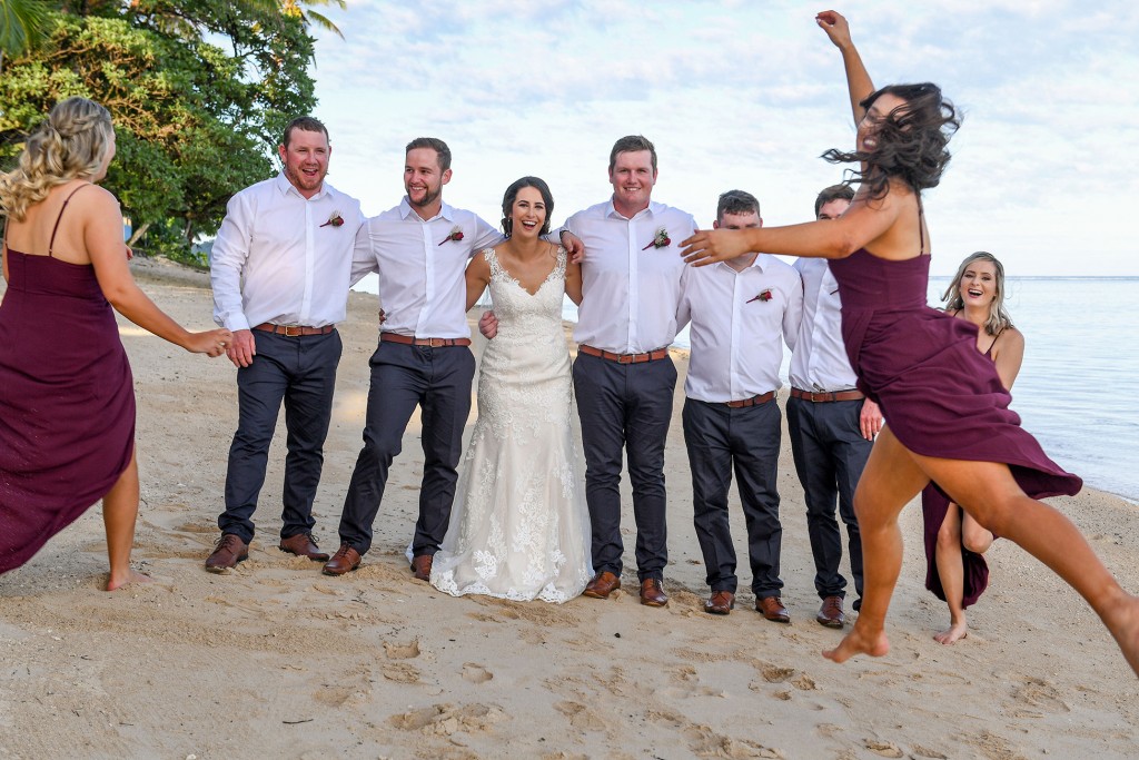 A bridesmaid photobombs the bride's and groomsmen's photo