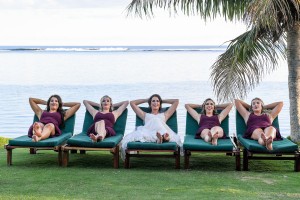 The bridesmaids relax on lounge chairs at the beach