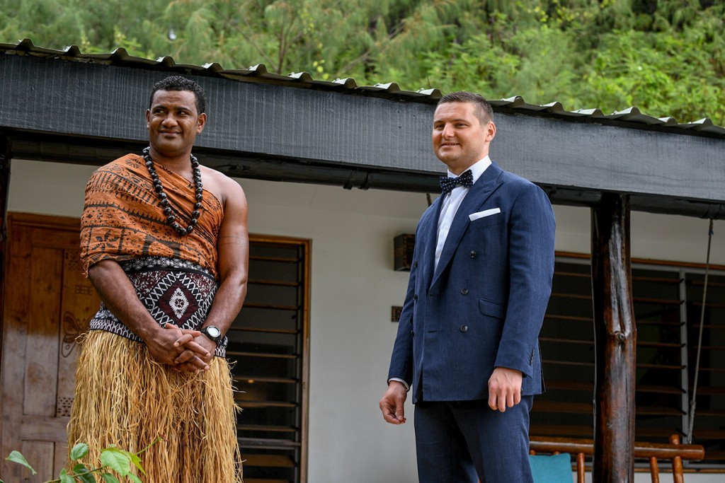The groom and a Fiji warrior wait patiently for the bride