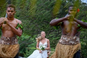 The bride walks down the aisle led by traditional Fiji warriors