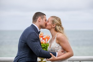 The newly weds kiss overlooking the Pacific Ocean