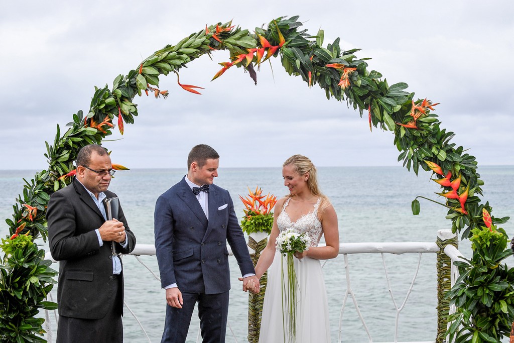 The newly weds hold hands at the beach view altar