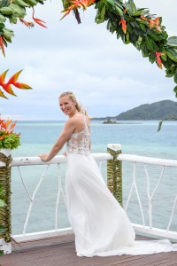 The bride poses at the altar by the Pacific ocean