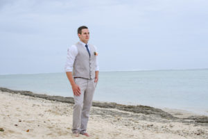 The groom stands alert on the beach