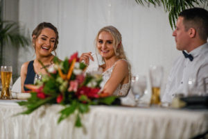 The bride laughs as she listens to a wedding speech