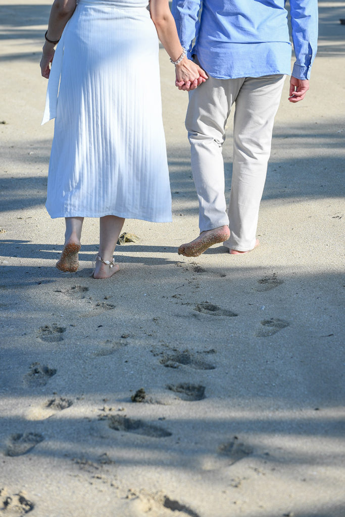 The honeymooning couple leaves footprints in the sand