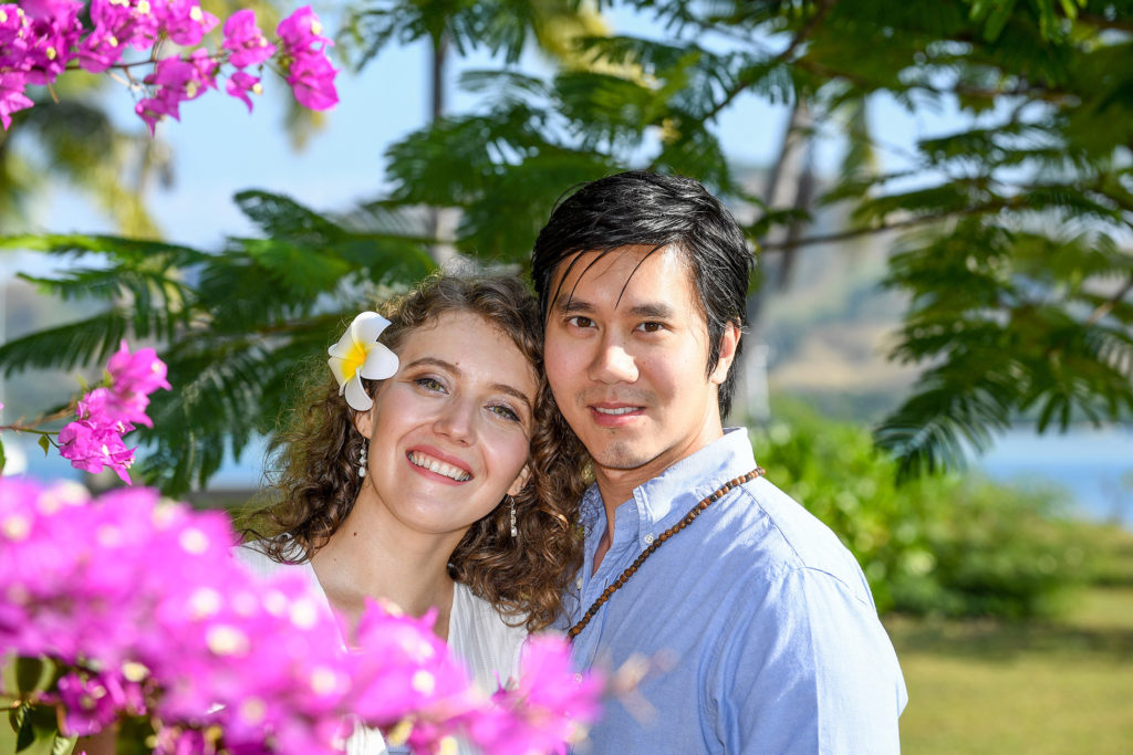 The loving couple is framed by purple Fiji flowers
