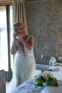 The bride puts on her earrings before the wedding ceremony
