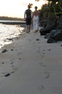 The newly weds leave footprints in the sand at Koro Sun beach