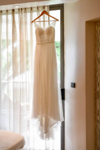 The royal white lace wedding gown hangs from the