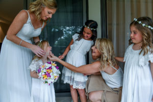 The bride and the flower girls share a light moment before the wedding ceremony
