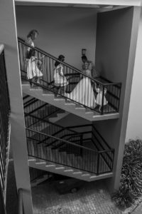 The bride and her flower girls make their way down a winding staircase