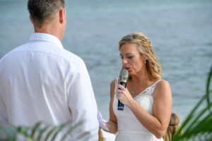 The bride reads her vows while standing at the altar overlooking the Pacific Ocean