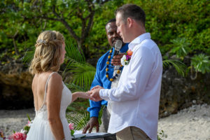 The groom says his vows as he slips the ring onto the bride's finger