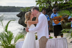 The newly weds kiss overlooking the glorious Pacific ocean