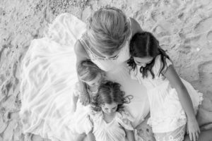 An overhead monochrome portrait of the bride hugging her three daughters
