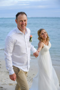 The groom leads his bride while on Shangri La beach