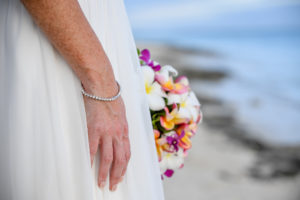The bride's diamond bracelet and colourful frangipani and tropical flower bouquet