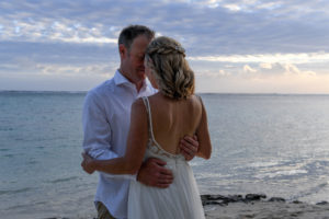 The newly wed couple embrace against the grey sunset of Shangri La Beach in Fiji