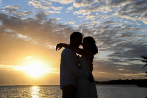 A silhouette of the newly weds kissing at sunset at Shangri La Fiji
